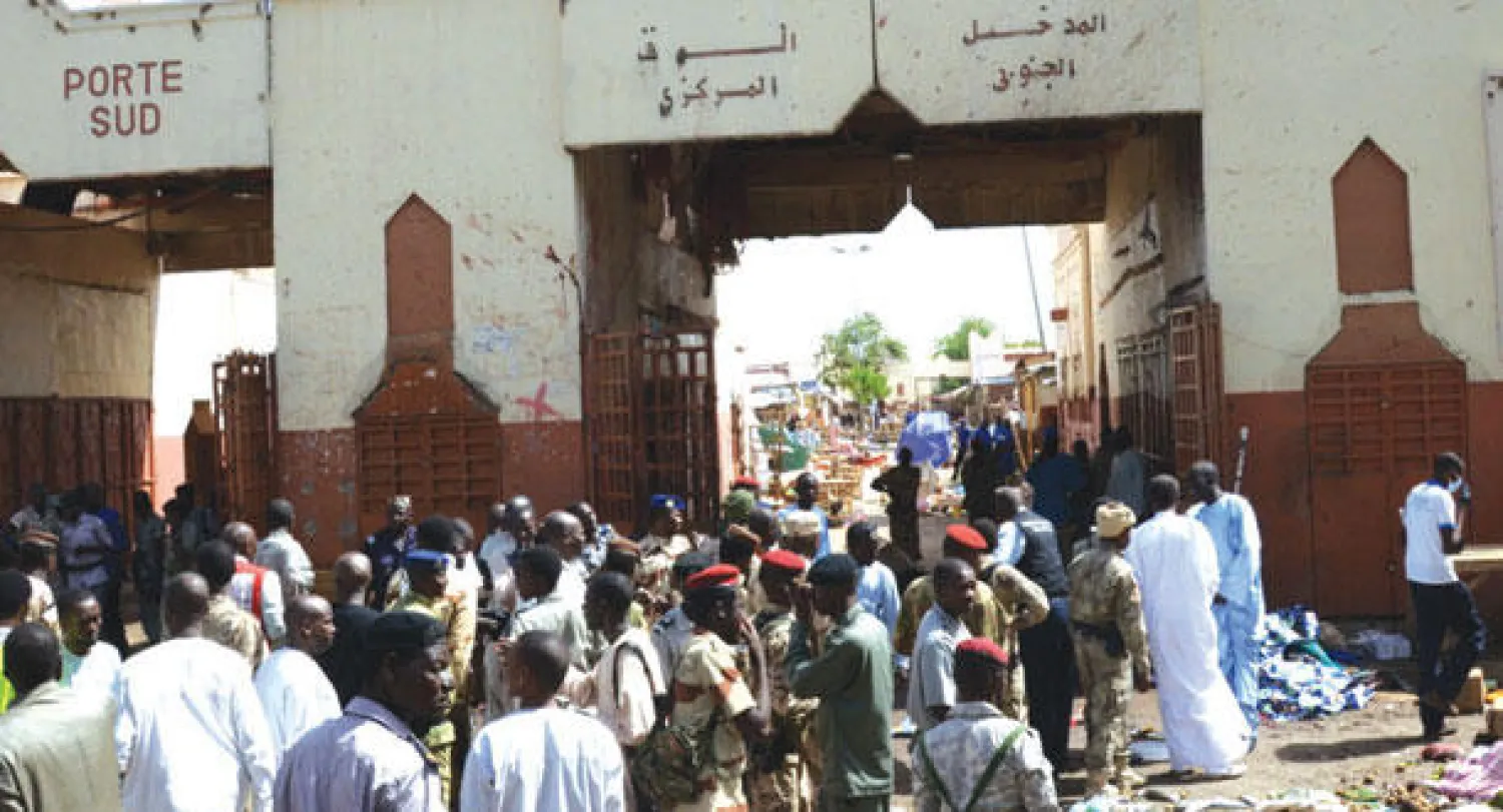 مواطنون ورجال أمن يتأملون آثار الدمار التي لحقت بالسوق بعد أن فجر انتحاري نفسه أمس مخلفا 14 قتيلا في قلب العاصمة التشادية (أ.ف.ب)