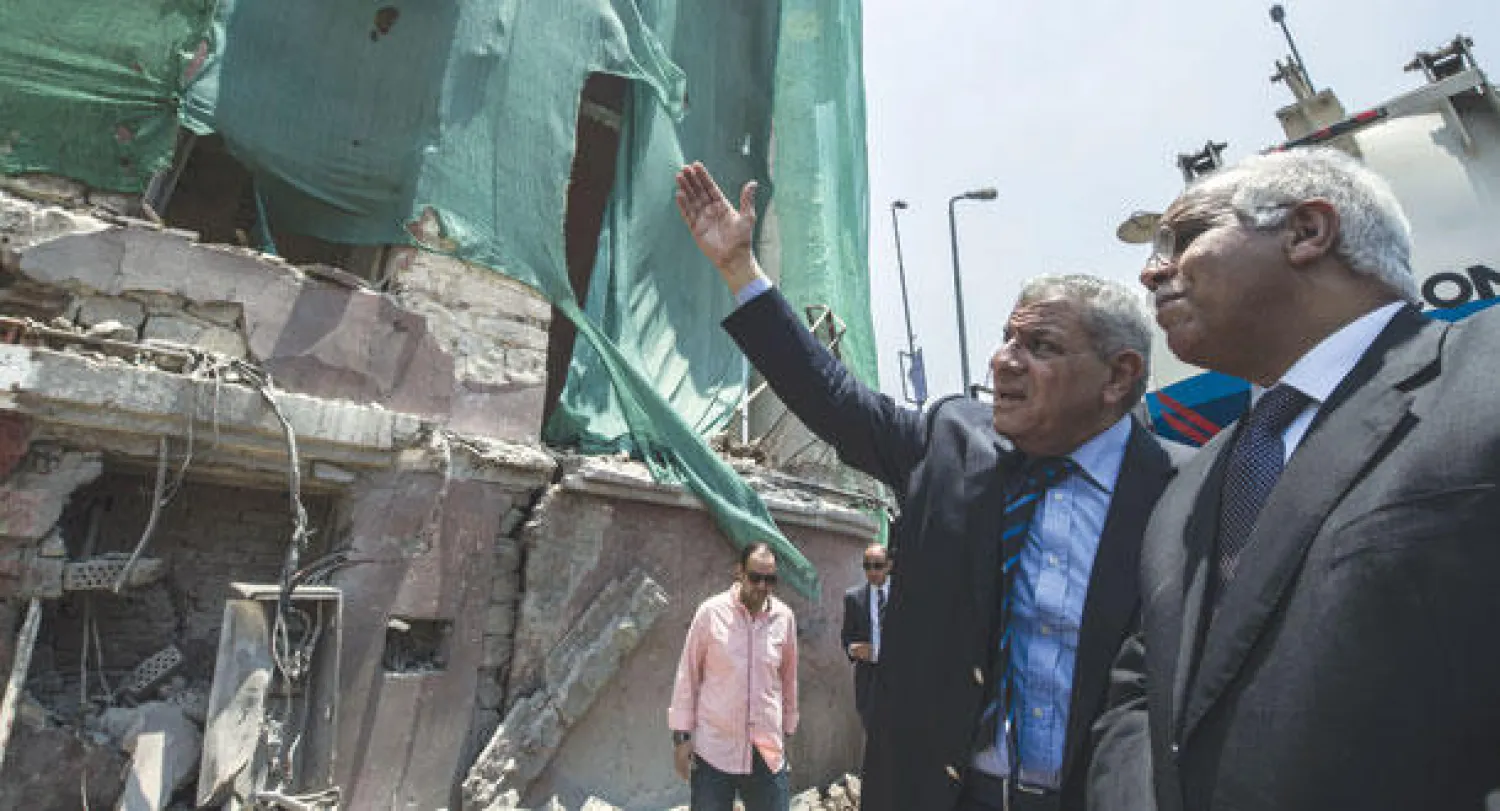 رئيس الوزراء المصري إبراهيم محلب ومحافظ القاهرة جلال السعيد يعاينان موقع القنصلية الإيطالية في القاهرة أمس بعد استهدافه يوم السبت الماضي (أ.ف.ب)