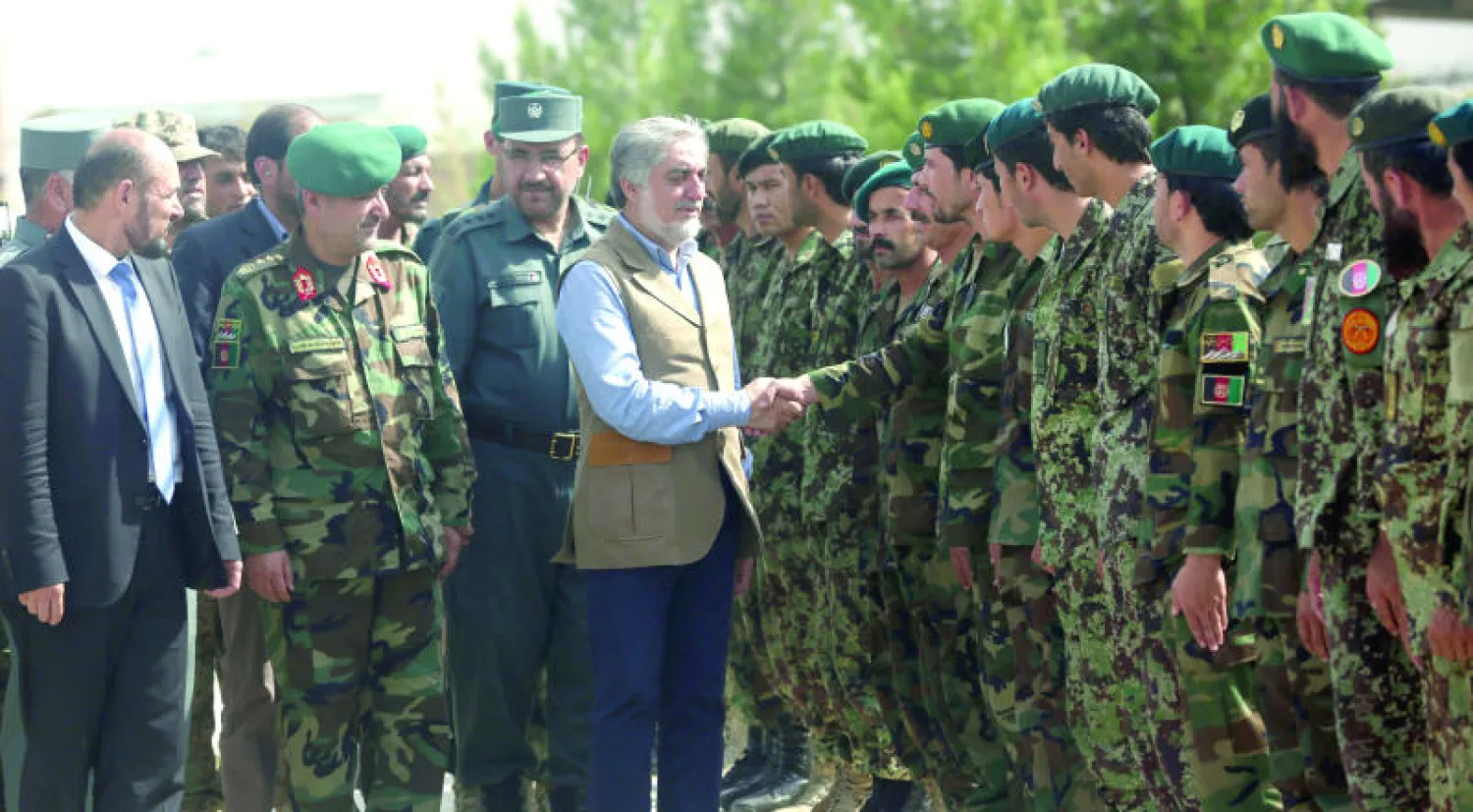 الدكتور عبد الله عبد الله رئيس وزراء حكومة الوحدة الوطنية الأفغانية يصافح جنودا لدى وصوله إلى فيض آباد عاصمة ولاية بادخشان قبل حلول عيد الفطر المبارك ضمن زياراته المكوكية للتأكيد على التصدي لعنف طالبان (أ.ب)