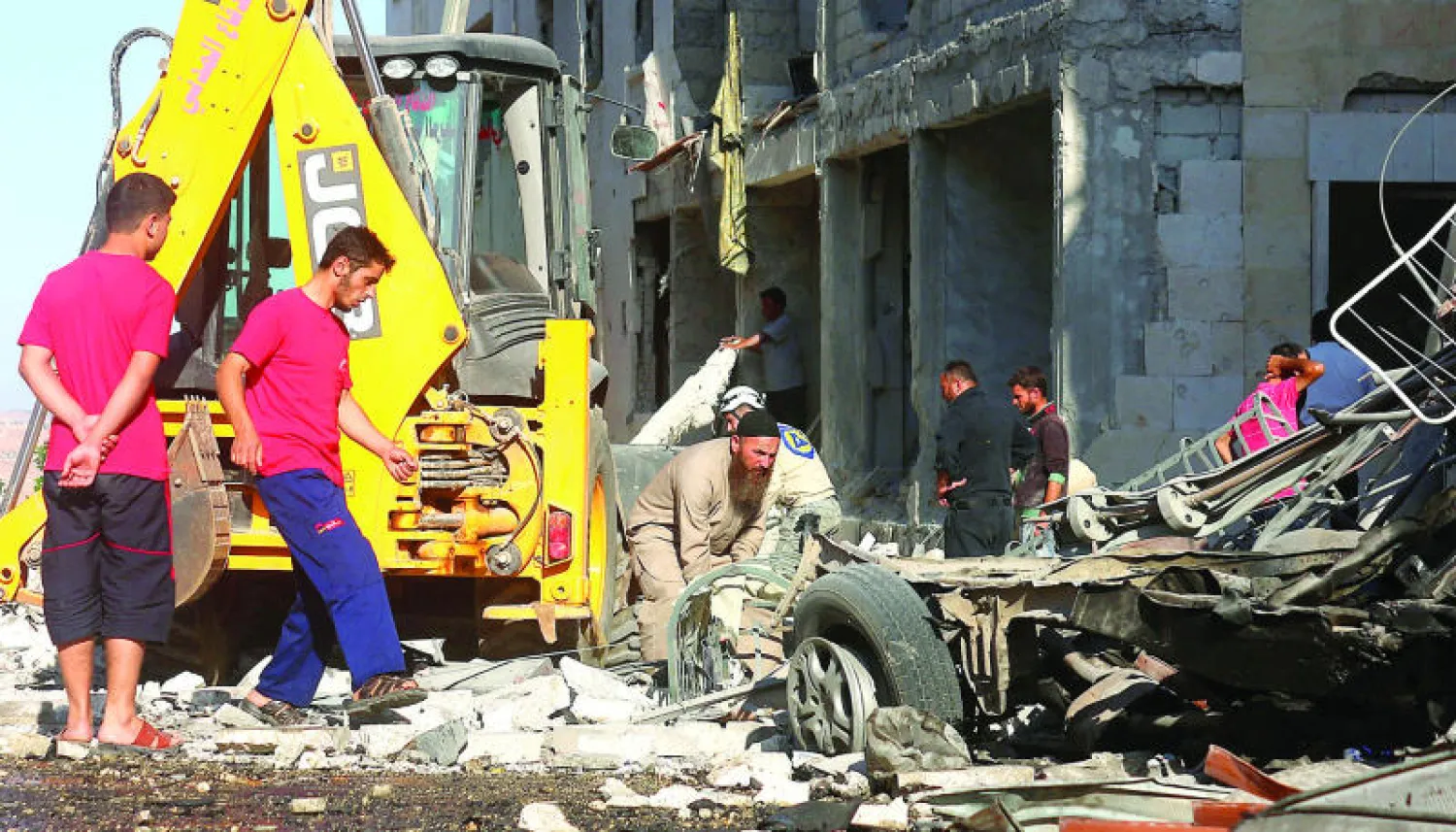 مواطنون يتفقدون الدمار الناجم عن قصف طيران النظام السوري لبلدة كفر حمرة في الضواحي الشمالية الغربية لمدينة حلب عاصمة الشمال السوري، بالبراميل المتفجرة (غيتي)