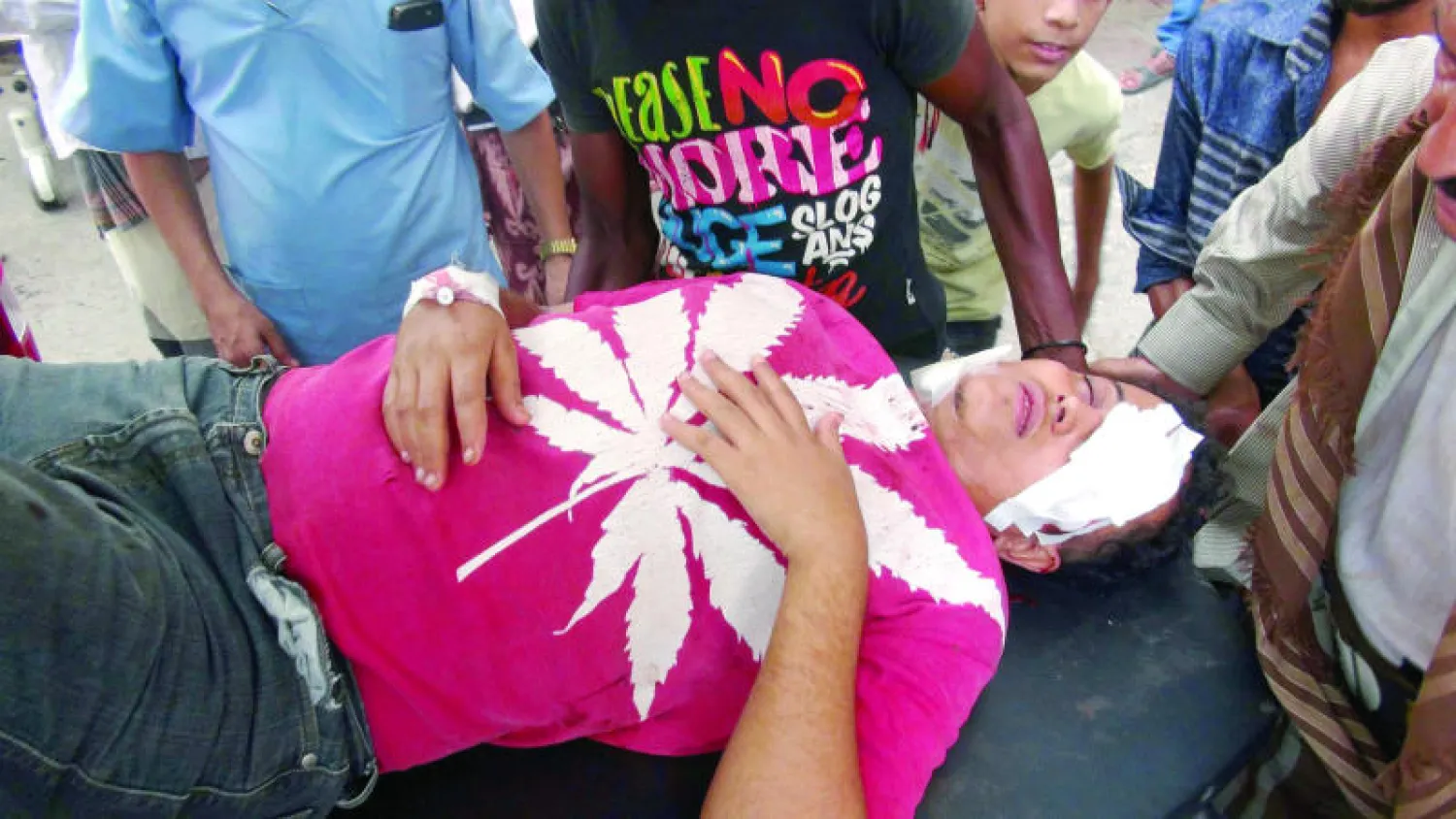 يمنيون يحاولون إسعاف رجل أصيب بجروح خطيرة جراء قصف الحوثيين لحي سكني في عدن المحررة من ميليشيات التمرد (أ.ب)