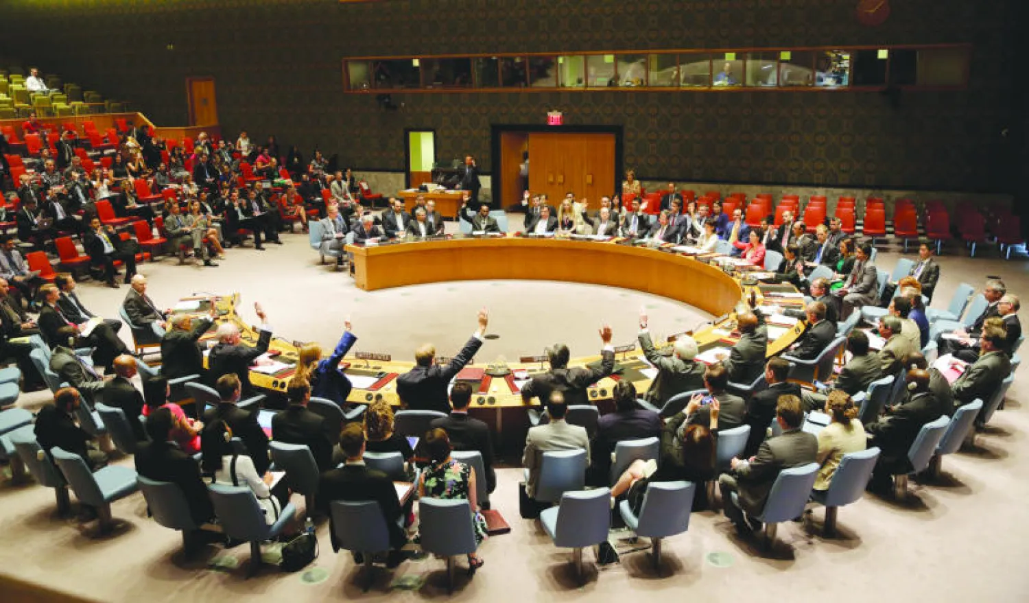 تصويت برفع الأيدي على قرار المصادقة على الاتفاق النووي مع إيران في مجلس الأمن الدولي أمس (أ.ب)