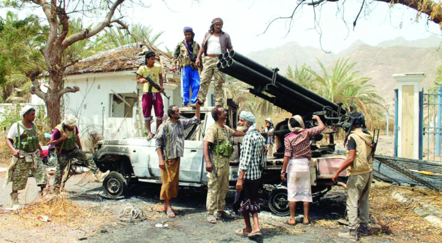 مقاتلون من المقاومة الموالية للشرعية يحيطون بقاذفة صواريخ معطوبة كان يستخدمها الحوثيون في منطقة التواهي بعدن أمس (أ.ف.ب)