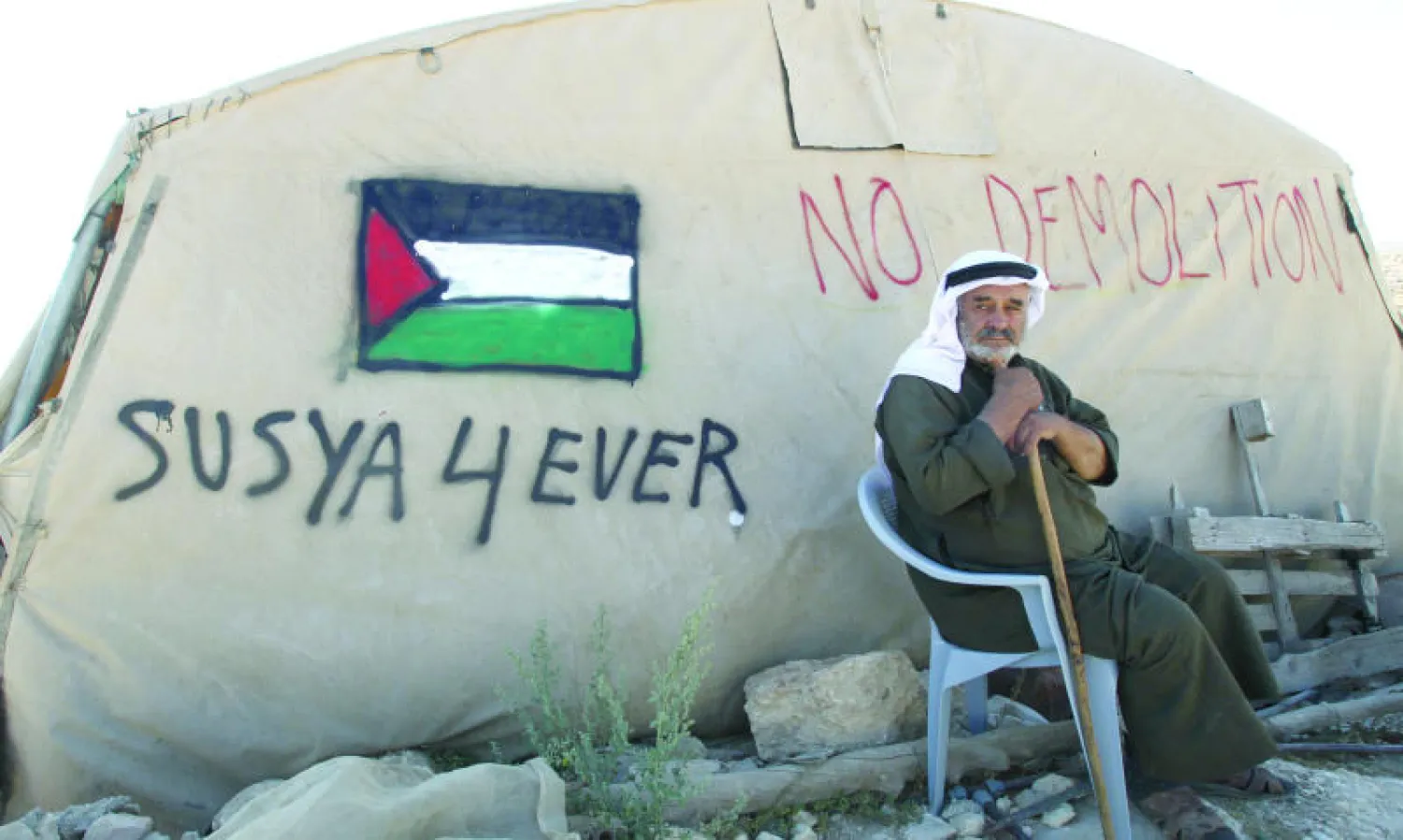 فلسطيني من قرية سوسية في الضفة الغربية التي قررت المحكمة الإسرائيلية العليا تهجير سكانها (340 نسمة) يجلس قرب خيمته المهددة بالإزالة (أ.ف.ب)