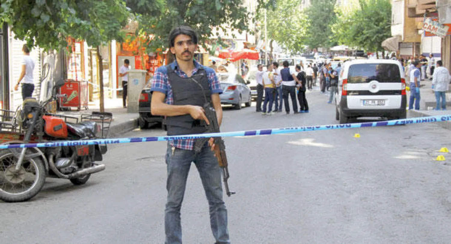 عنصر أمن تركي يقوم بحراسة المكان الذي شهد الهجوم على مركز حدودي في مدينة دياربكر أمس (رويترز)