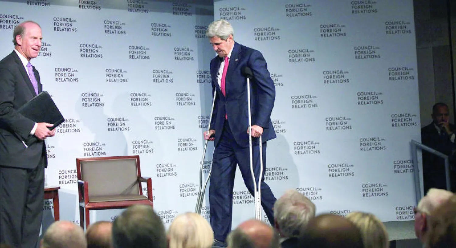 وزير الخارجية الأميركي جون كيري يستعين بعكازيه لدخول قاعة مجلس العلاقات الخارجية بنيويورك لمناقشة الاتفاق النووي، يوم أمس (أ.ف.ب)