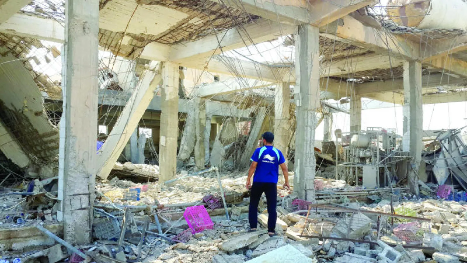 عراقي يقف وسط أنقاض بناية دمرها قصف جوي في الفلوجة أمس (إ.ب.أ)