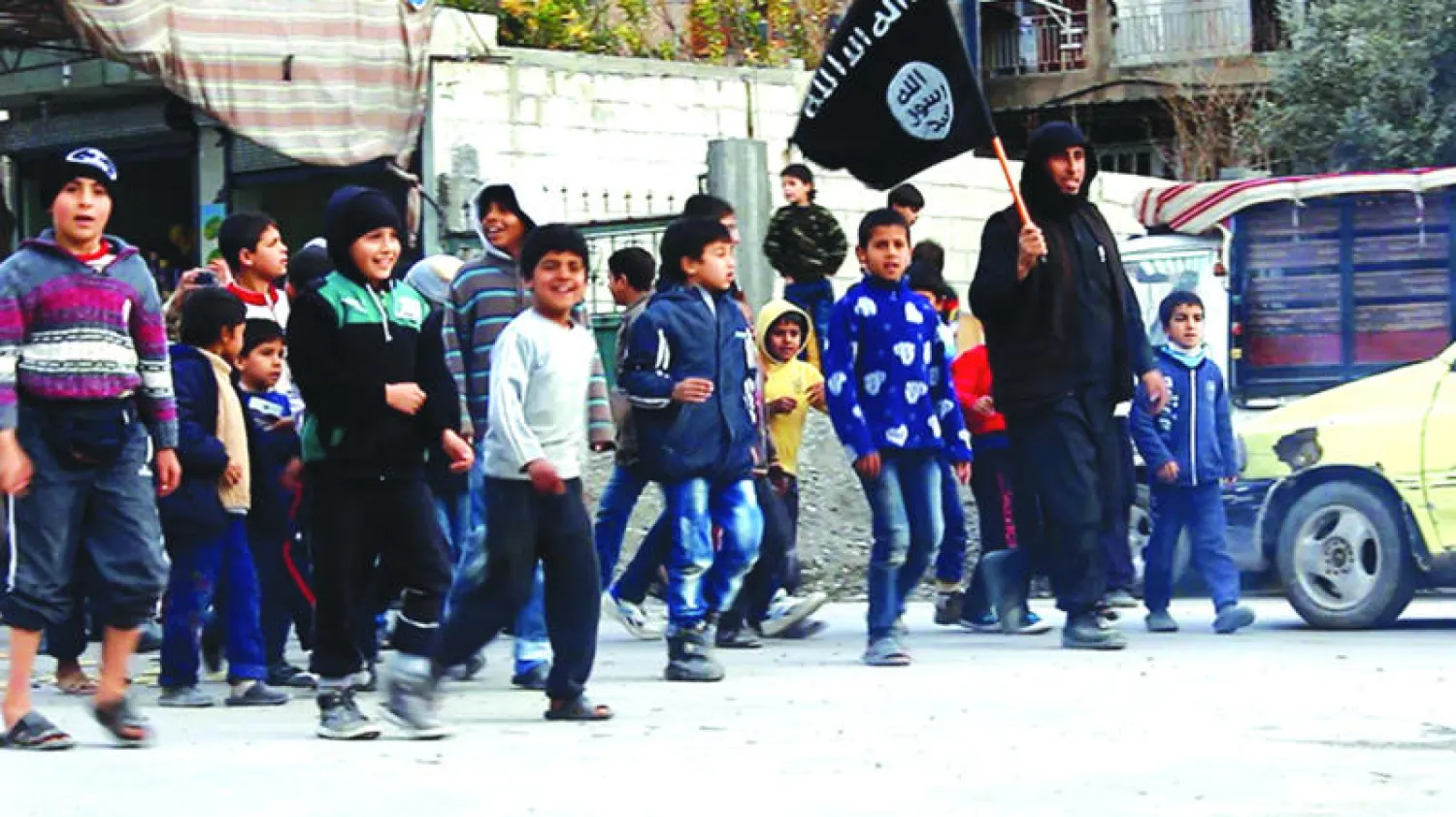 أطفال من مدينة الطبقة التابعة لمحافظة الرقة يقودهم معلم من «داعش».. الصورة تعود إلى بداية العام الحالي (أ.ب)