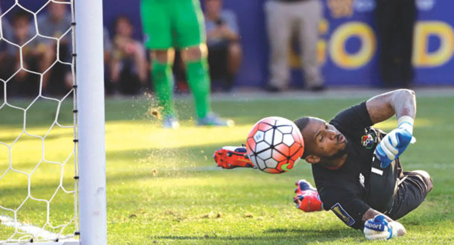 الحارس البنمي لويس ميخيا يتصدى لركلة ترجيح الأميركي برادلي (إ.ب.أ)