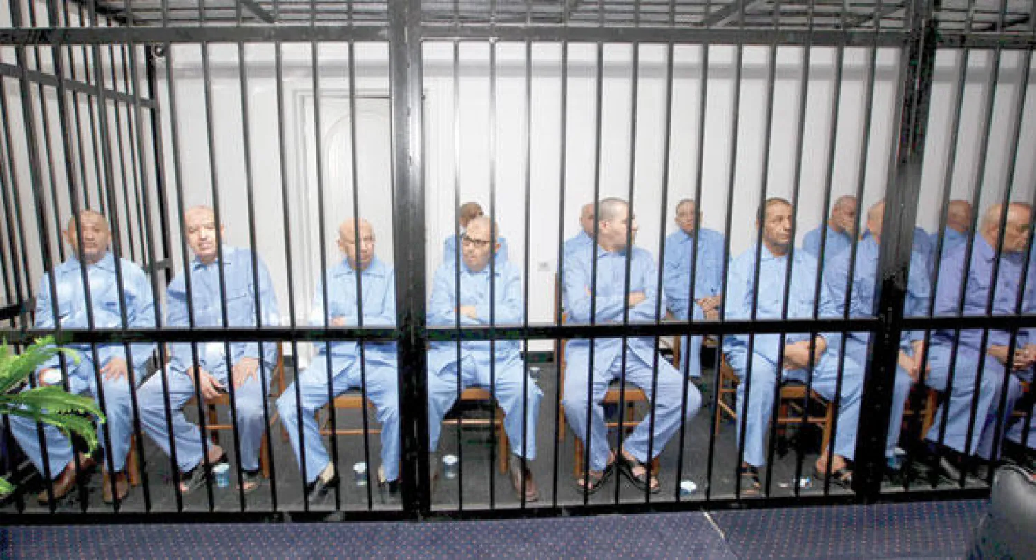 المتهمون داخل قفص الاتهام بمحكمة استئناف طرابلس أثناء الاستماع للحكم الذي صدر بحقهم أمس (رويترز)