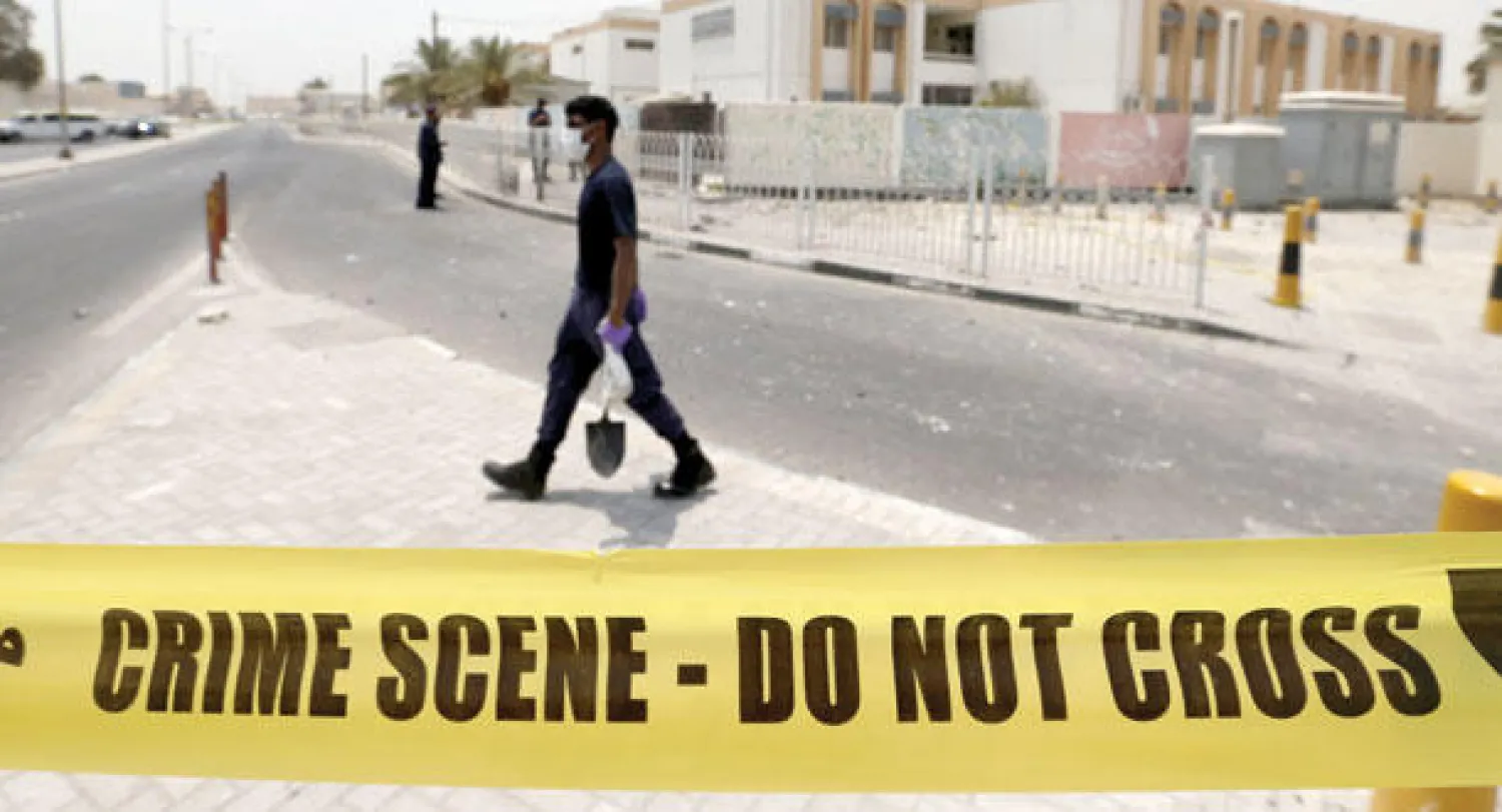 خبير متفجرات ينقل في حقيبته أدلة جنائية تم جمعها من مكان التفجير في قرية سترة البحرينية منذ أيام (رويترز)