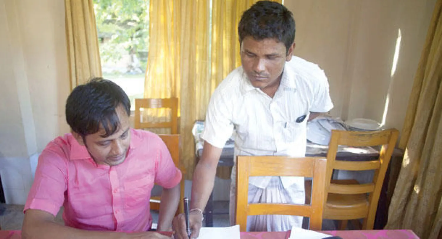 محمد موانول يوقع على دفتر لإلغاء ملفه الخاص بالهجرة إلى الهند بعد توقيع اتفاق تاريخي بين بنغلاديش والهند حول منطقة حدودية يتيح لخمسين ألف شخص يقيمون في جيوب على جانبيها اختيار الانتماء إلى أحد هذين البلدين (أ.ف.ب)