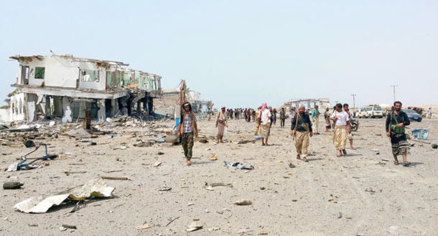 مقاتلون من المقاومة يتجمعون أمام «نقطة العلم» الواقعة في المدخل الشرقي لمدينة عدن بعد طرد المتمردين منها أمس (رويترز)مقاتلون من المقاومة يتجمعون أمام «نقطة العلم» الواقعة في المدخل الشرقي لمدينة عدن بعد طرد المتمردين منها أمس (رويترز)