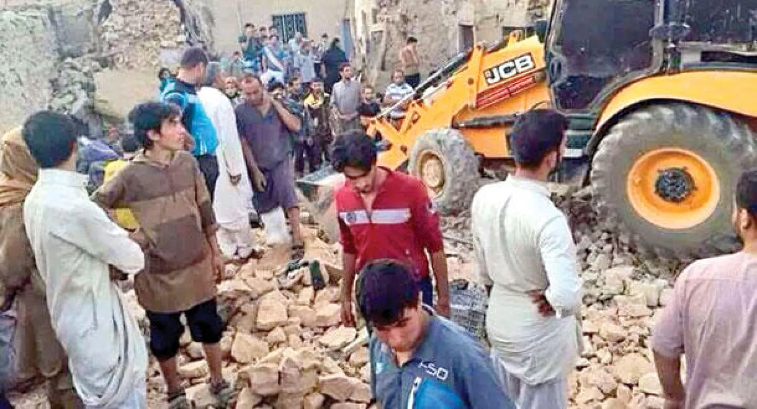 عراقيون في مدينة الرطبة بمحافظة الأنبار يراقبون عمليات إنقاذ بعض الأحياء من تحت ركام البيوت التي هدمها القصف الجوي أمس («الشرق الأوسط»)