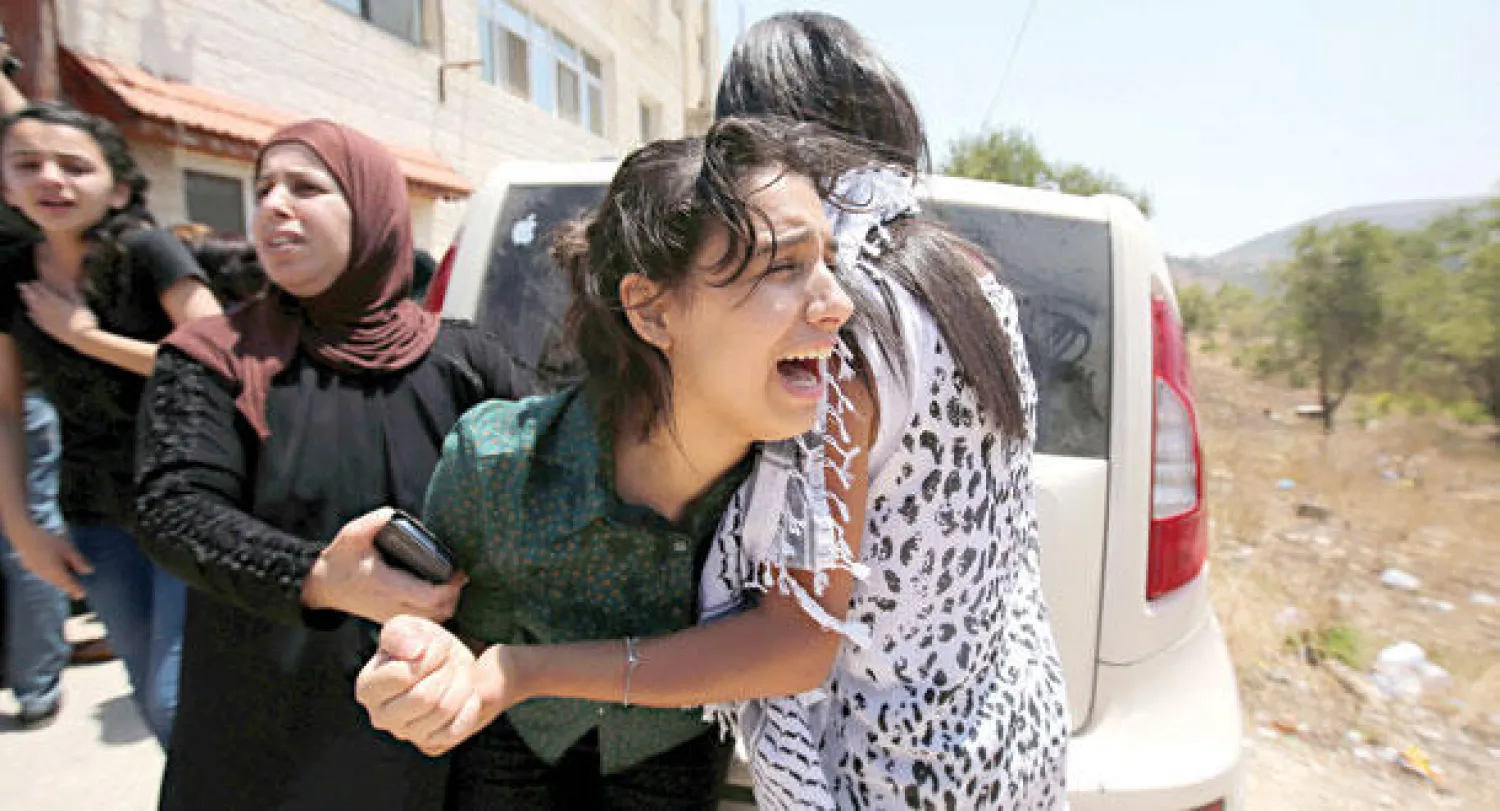 فليسطينية تواسي أحد أفراد عائلة شاب فلسطيني قتل أمس بواسطة الجيش الإسرائيلي (أ.ف.ب)