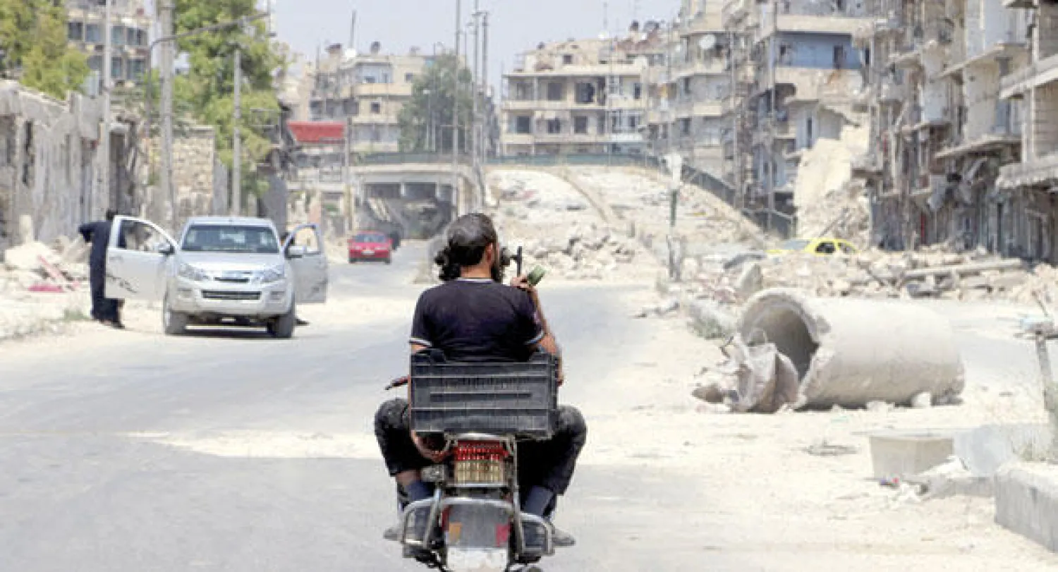 أثنان من المقاتلين السوريين على دراجة نارية قرب جسر الشعار الذي أغلقه المقاتلون أمس (رويترز)