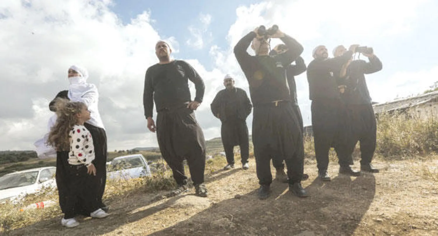 رجال دين دروز في مرتفعات الجولان المحتلة يتابعون معارك مدينة الحضر الحدودية بين قوات محلية ومقاتلي «النصرة» الشهر الماضي (إ.ب.أ)