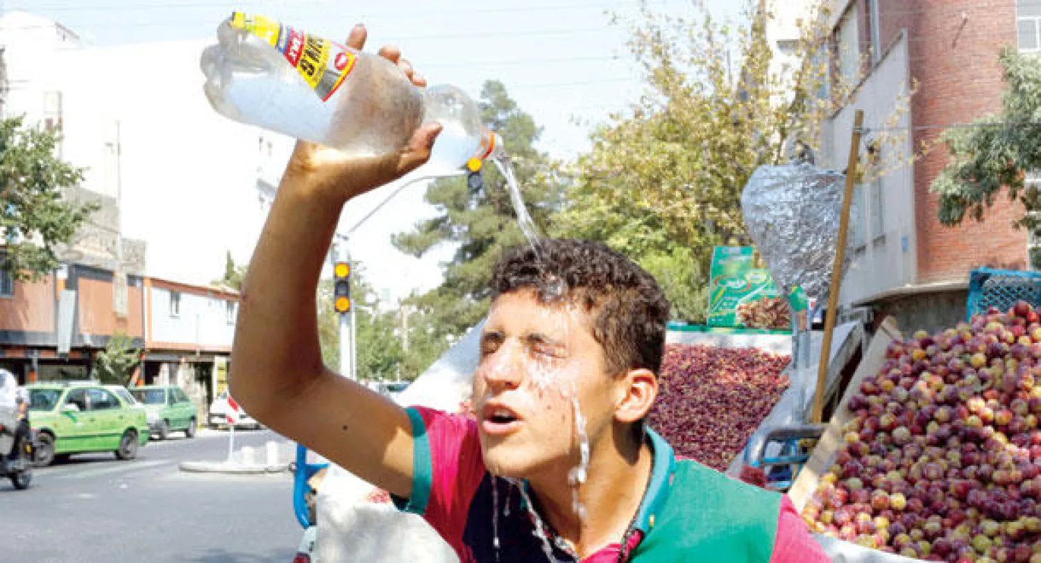 بائع متجول إيراني يسكب على رأسه الماء بسبب درجة الحرارة المرتفعة في طهران التي فاقت 40 درجة مئوية في بعض مناطق البلاد يوم أمس (إ.ب.أ)