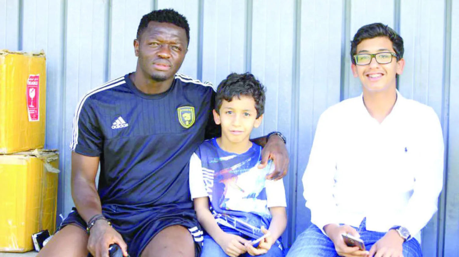 مونتاري لاعب الاتحاد مع طفلين سعوديين في معسكر الفريق الخارجي (المركز الإعلامي بنادي الاتحاد)