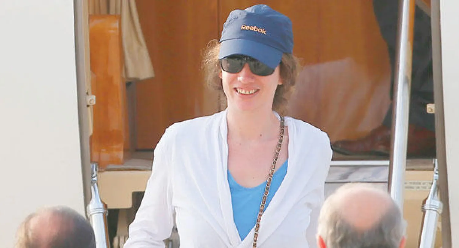 الرهينة الفرنسية المحررة إيزابيل بريم لدى استقبالها من قبل الرئيس هولاند ووزير الخارجية فابيوس بقاعدة جوية قرب باريس أمس (إ.ب.أ)