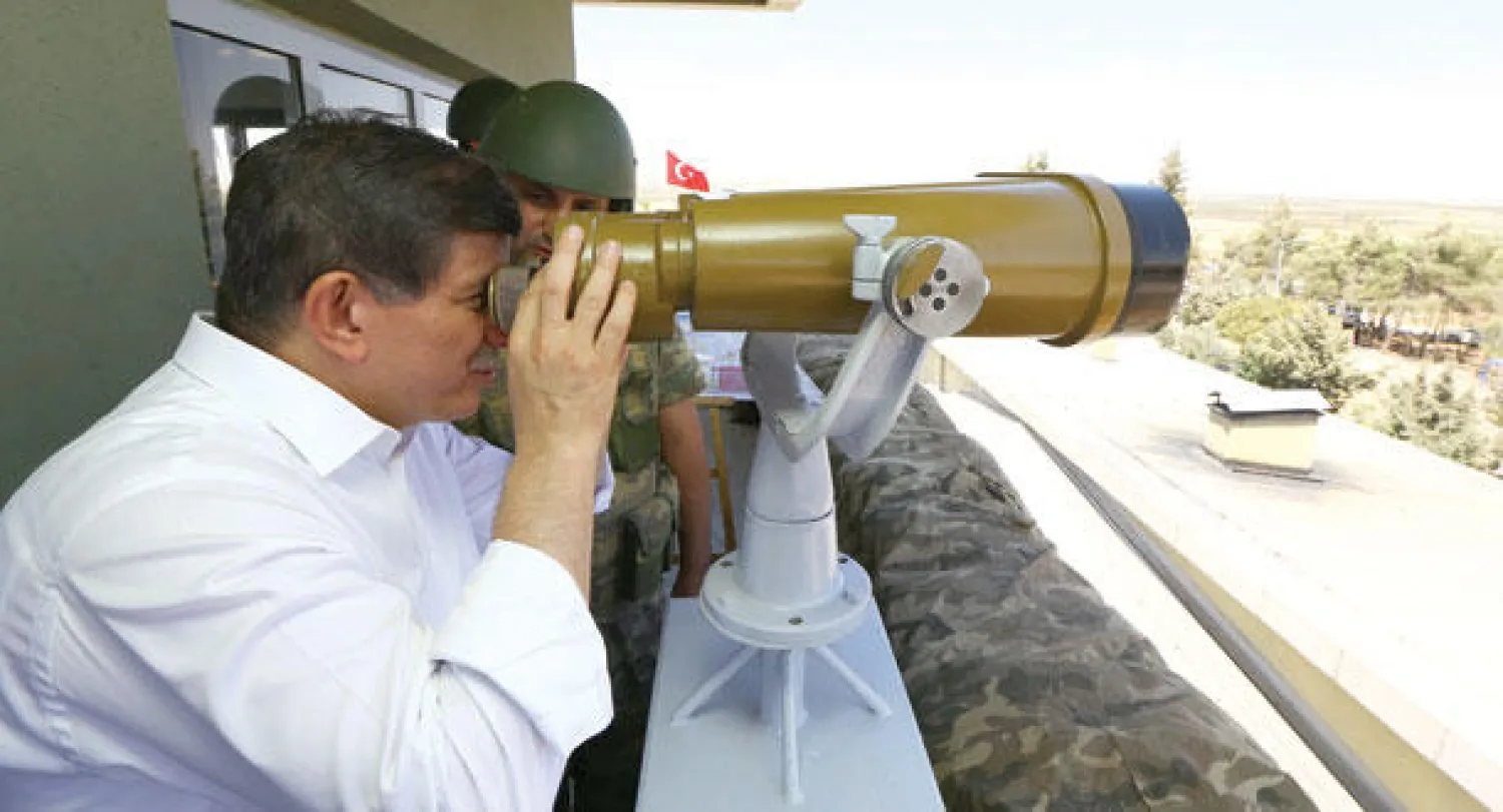 داود أوغلو خلال زيارته أمس موقعا أماميا حدوديا في منطقة كلس قرب الموقع الذي قتل فيه جندي في اشتباكات مع متشددي تنظيم داعش في الشهر الماضي على الجانب السوري من الحدود (إ.ب.أ)