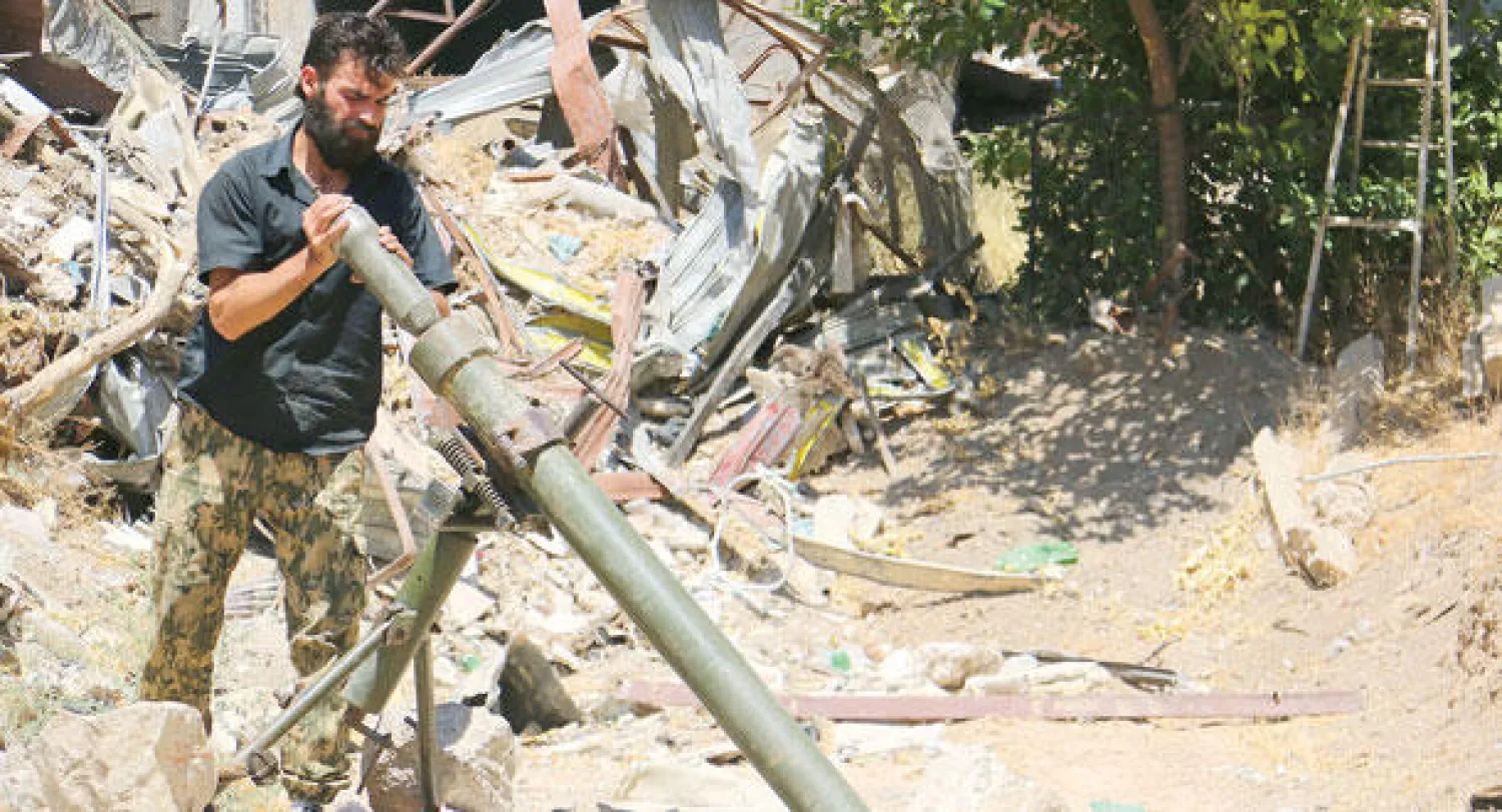 أحد الثوار السوريين يعد مدفع هاون في مواجهة جيش النظام في دمشق أمس (غيتي)