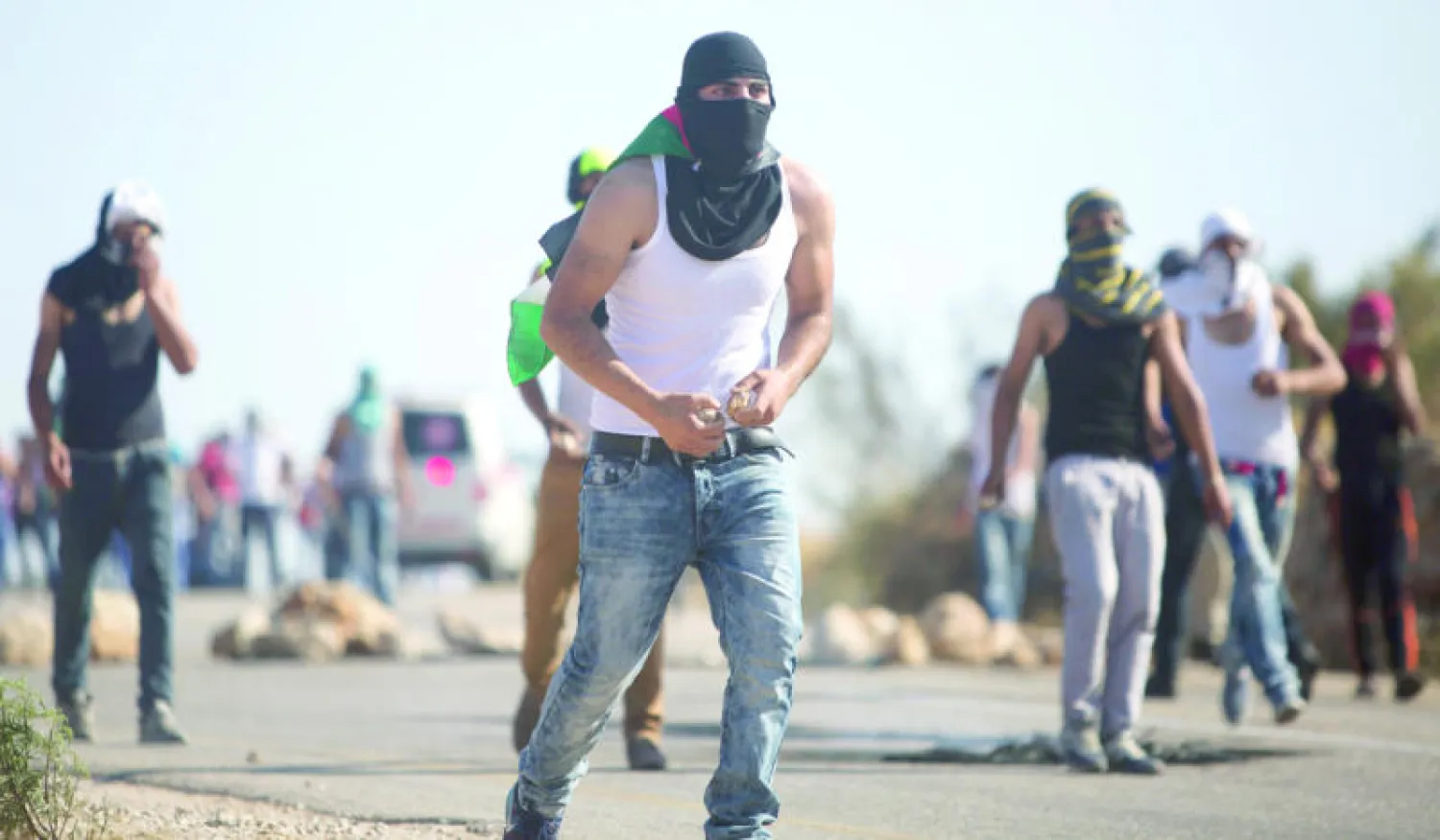 شبان فلسطينيون يرشقون قوات الأمن الإسرائيلية بالحجارة خلال صدامات أعقبت تشييع جثمان سعد دوابشة (أ.ب)