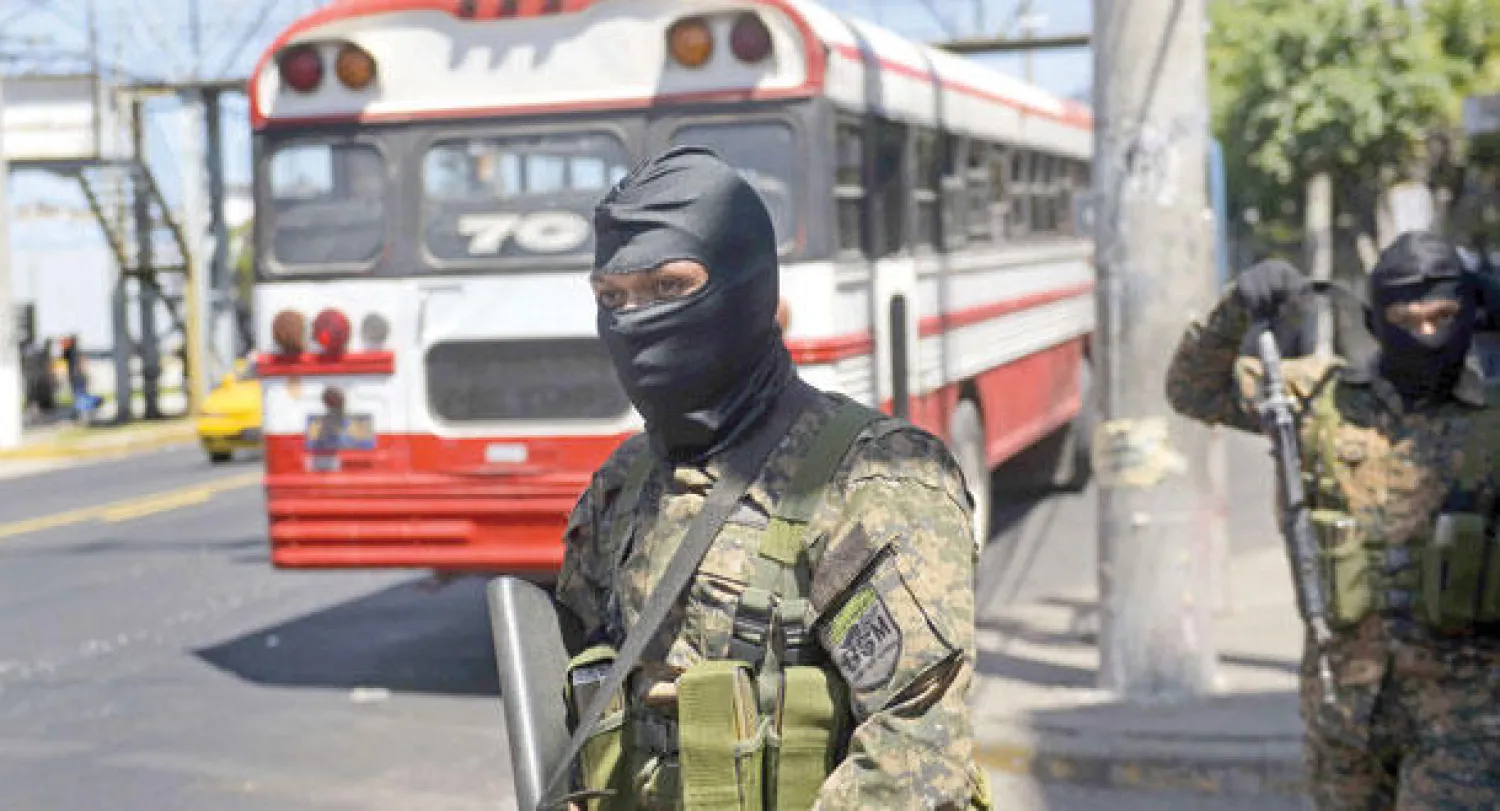 جندي من القوات الخاصة يحرس واحدة من الحافلات التي تدور في سان سلفادور (أ.ف.ب)