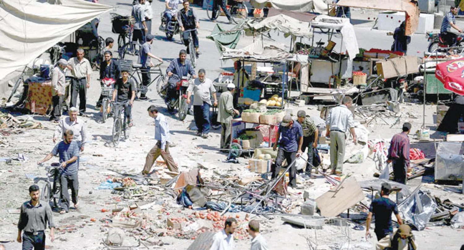 مدنيون في سوق منطقة دوما بريف دمشق يتفحصون الدمار الذي لحق بسوق الخضار بعد استهدافه بغارة من طيران النظام قتلت ما لا يقل عن 37 شخصًا (رويترز)