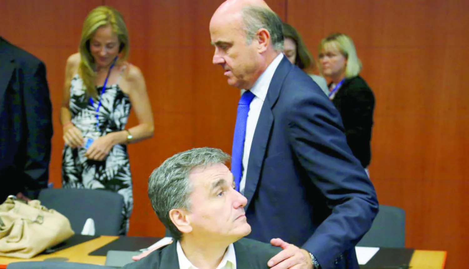 وزير الاقتصاد الإسباني يحيي وزير المالية اليوناني خلال اجتماع وزراء مالية منطقة اليورو في بروكسل أمس (رويترز)