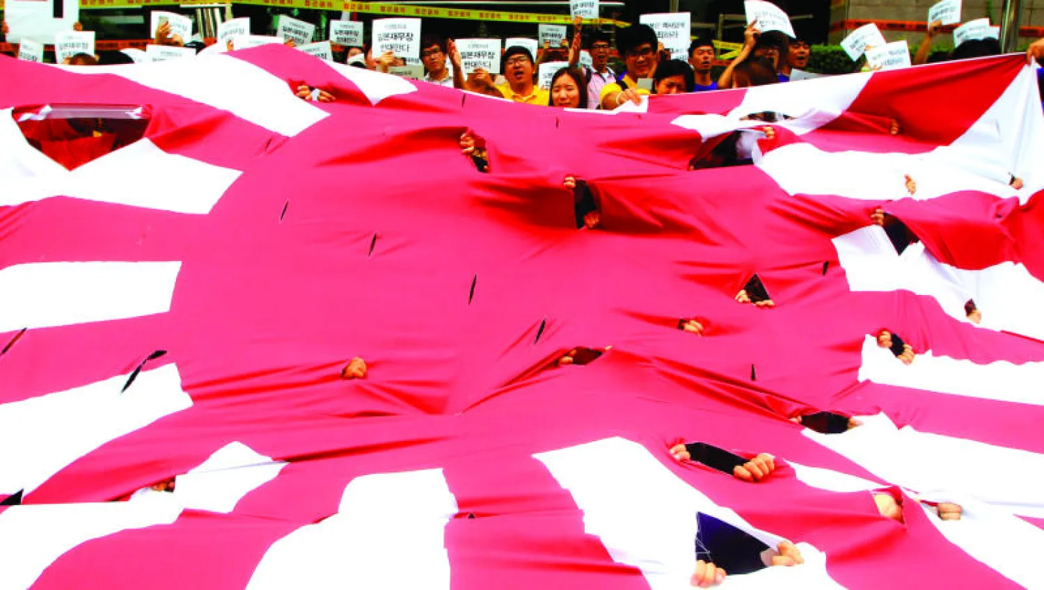 طلبة من كوريا الجنوبية يتظاهرون أمام السفارة اليابانية في العاصمة سيول في الذكرى الـ70 للحرب العالمية الثانية مطالبين اليابان بالاعتذار عن ويلات الحرب التي شهدتها دول المنطقة (إ.ب.أ)