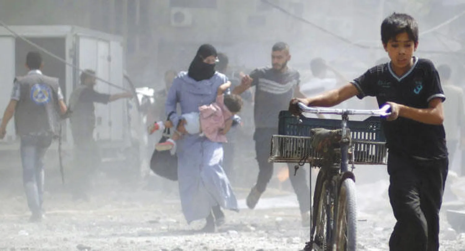 طفل سوري مع دراجته في مدينة دوما قرب دمشق أثناء هروب عائلات من قصف طيران الحرب السوري أمس (أ.ف.ب)
