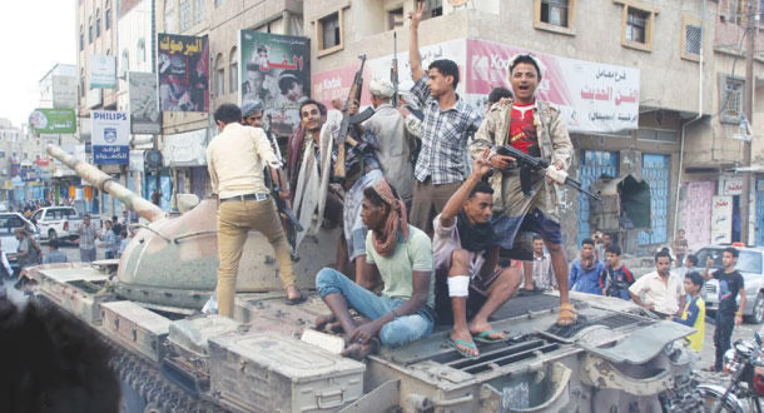 عناصر من المقاومة الشعبية على متن دبابة استولوا عليها بعد فرار الحوثيين من مركز مدينة تعز أمس  (رويترز)