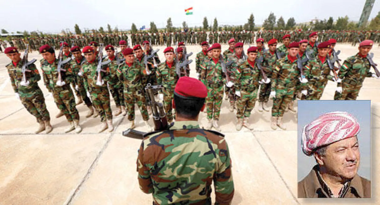 قوات من البشمركة أثناء مراسم احتفالية في أبريل الماضي وفي الإطار مسعود بارزاني (أ.ف.ب)