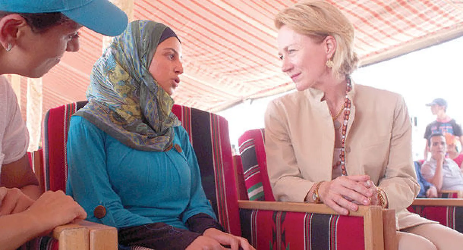 السفيرة الأميركية في العاصمة الأردنية أليس ويلز تتحدث إلى ناشطة في مجال تعليم الفتيات السوريات اللاجئات في مخيم الأزرق شمال الأردن أمس ضمن مساعيها لاستكمال اللاجئات السوريات تعليمهن (أ.ب)