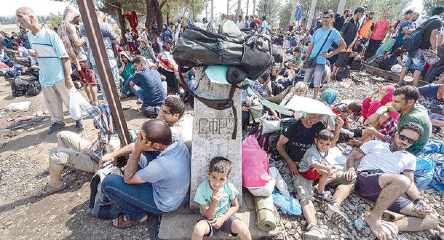 مهاجرون سوريون ينتظرون عند الحدود اليونانية المقدونية للسماح لهم بدخول مقدونيا ضمن هجرتهم نحو دول الاتحاد الأوروبي (إ.ب.أ)