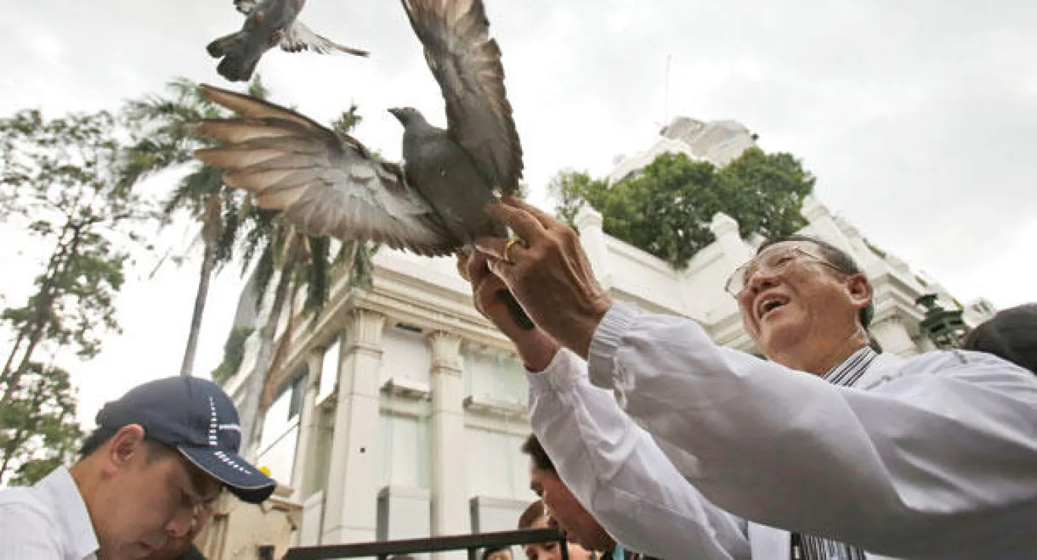 زائرون يطلقون حمائم السلام في ضريح إيراوان قرب مكان تفجير يوم الإثنين الماضي الدامي في العاصمة بانكوك يوم أمس (أ.ب)