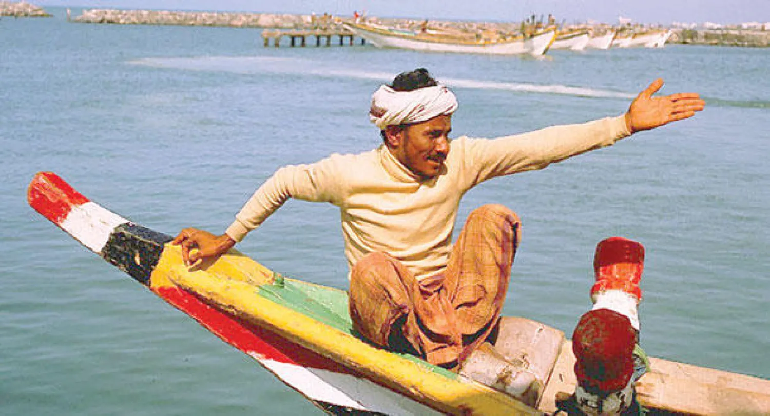 صياد يمني يجلس فوق أحد المراكب الشراعية في محافظة الحديدة (غيتي)