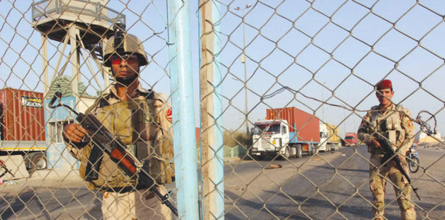 عنصرا أمن يحرسان الطريق المؤدي إلى ميناء أم قصر جنوب العراق أول من أمس (رويترز)