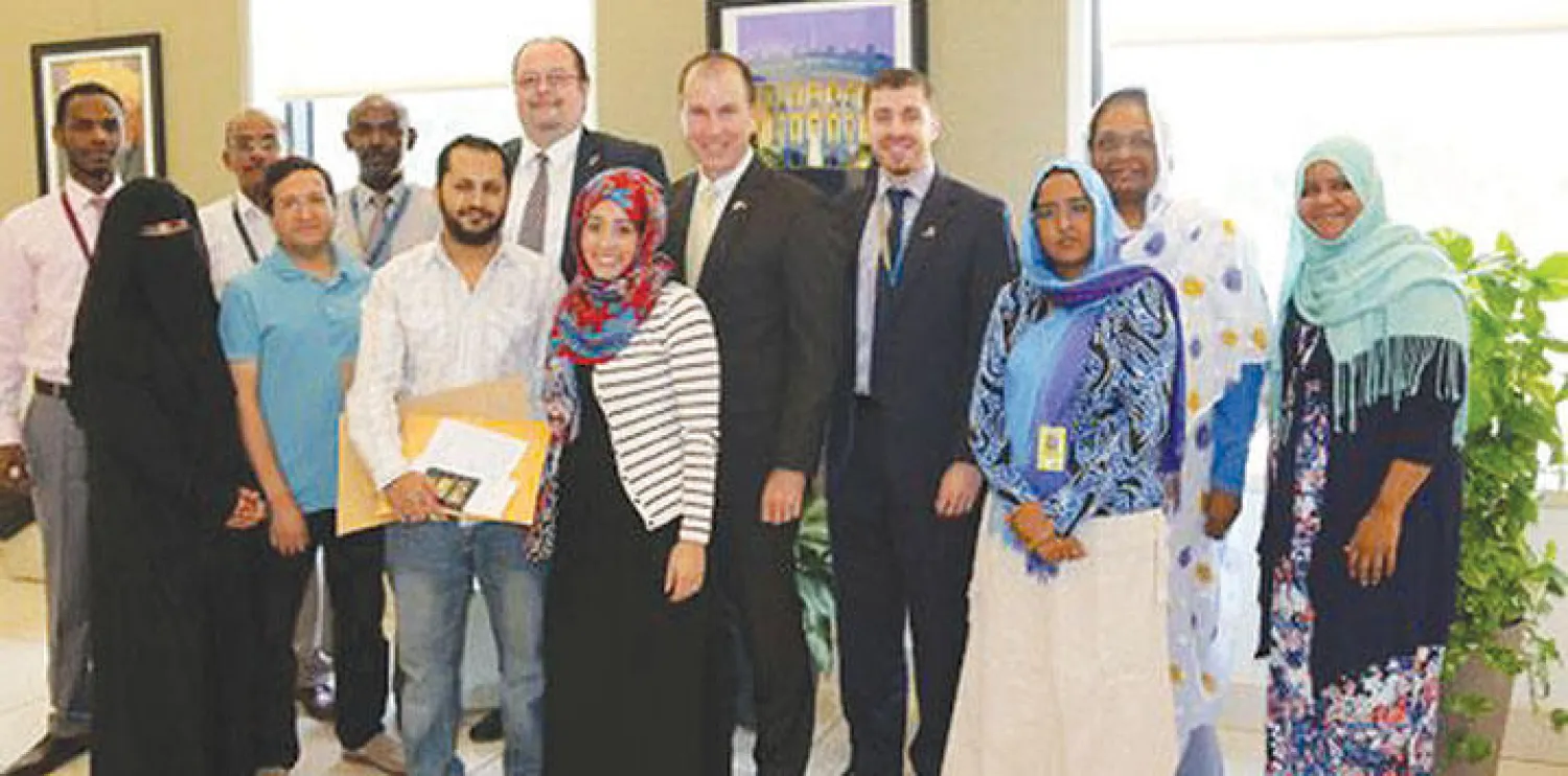 عدد من العاملين في السفارة الأميركية بالخرطوم مع بعض المهاجرين السودانيين ({الشرق الأوسط})