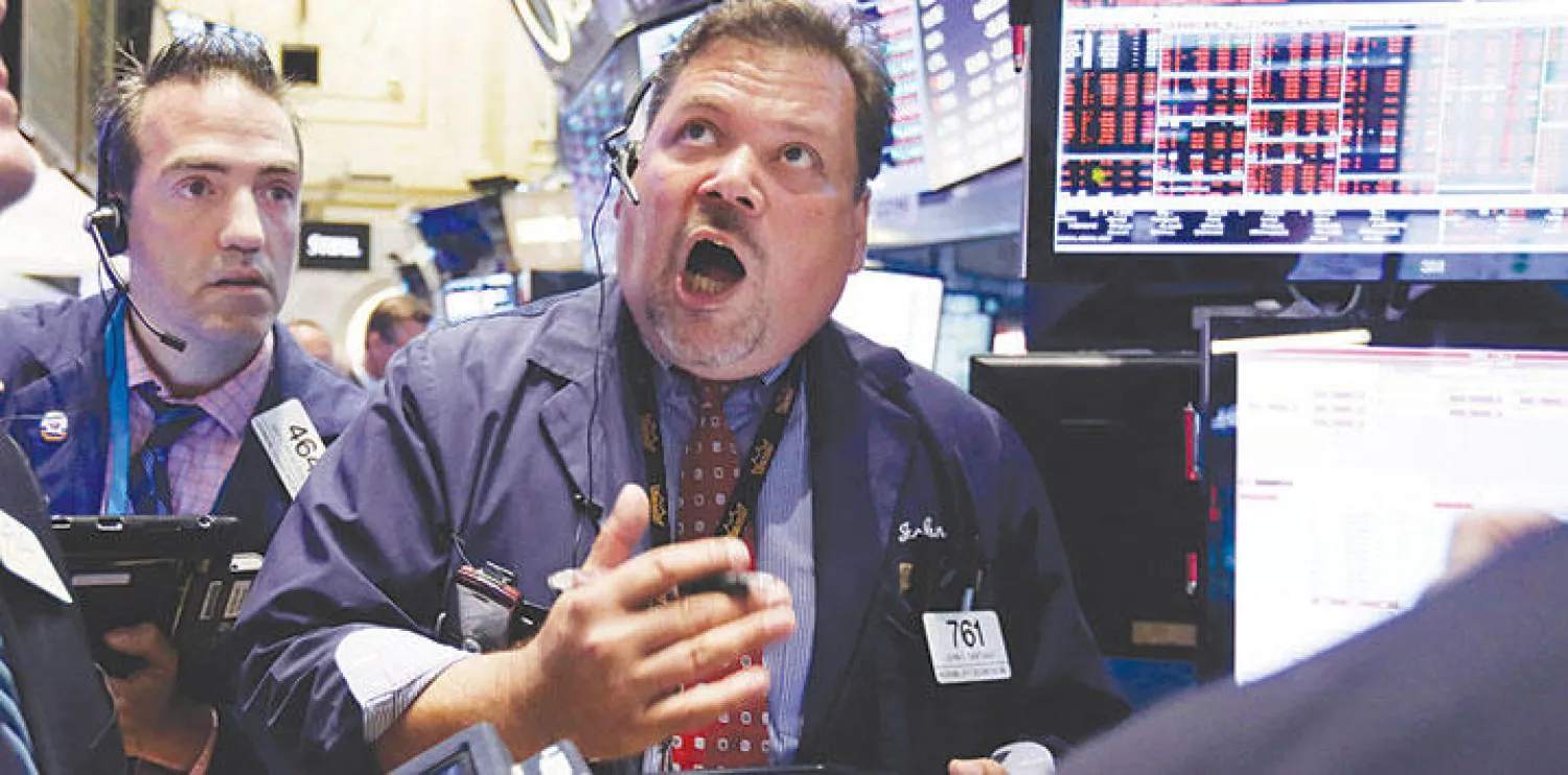 علامات الصدمة على وجهي موظفين في بورصة نيويورك أمس بعد هبوط الأسهم الصينية (أ.ب)