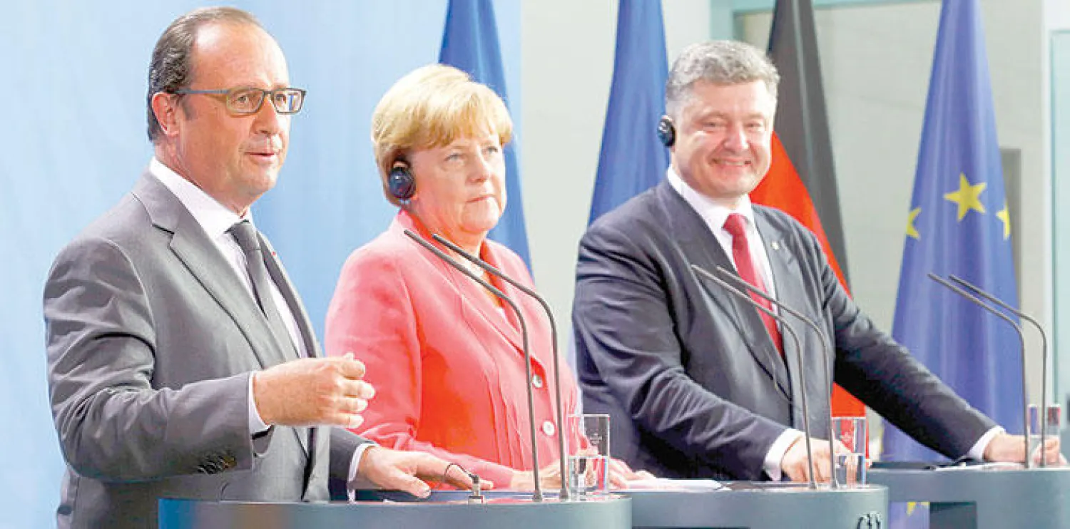 الرئيس الفرنسي فرنسوا هولاند إلى جانب المستشارة الألمانية انجيلا ميركل والرئيس الأوكراني بترو بوروشينكو خلال مؤتمر صحافي في برلين (رويترز)