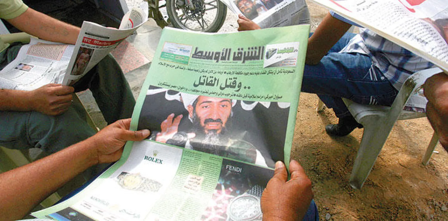 عراقي يطالع الصفحة الأولى من «الشرق الأوسط» في بغداد (غيتي)