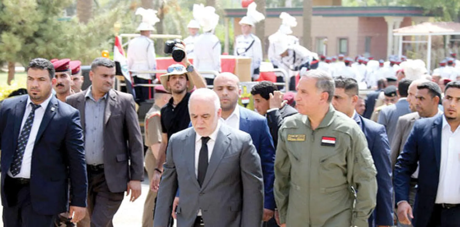 رئيس الحكومة العراقية حيدر العبادي ووزير الدفاع خالد العبيدي خلال تشييعهما للقائدين العسكريين اللذين قضيا صباح أمس في الرمادي (أ.ف.ب)