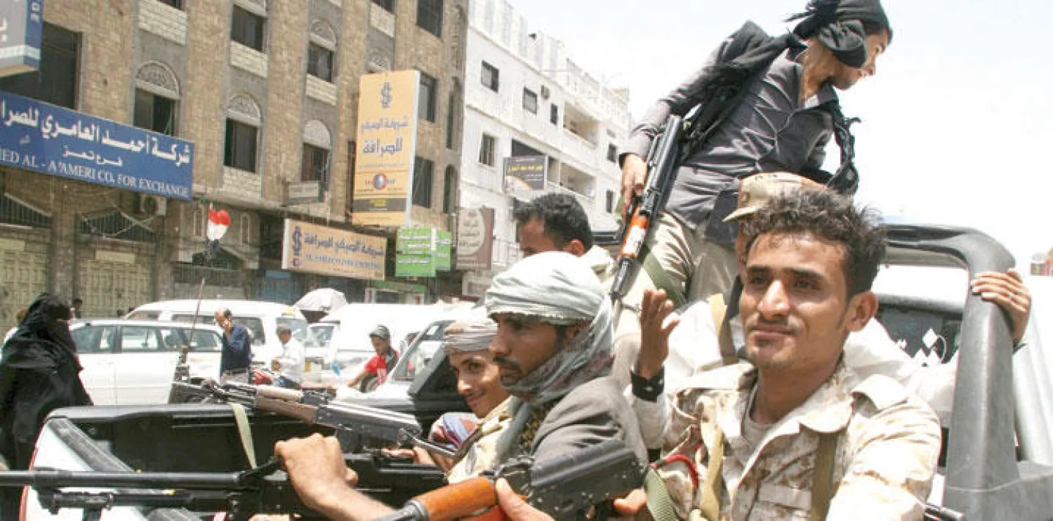 مجموعة مقاتلين من المقاومة الشعبية يستقلون إحد العربات بعد دحرهم الميليشيات الحوثية في تعز (رويترز)