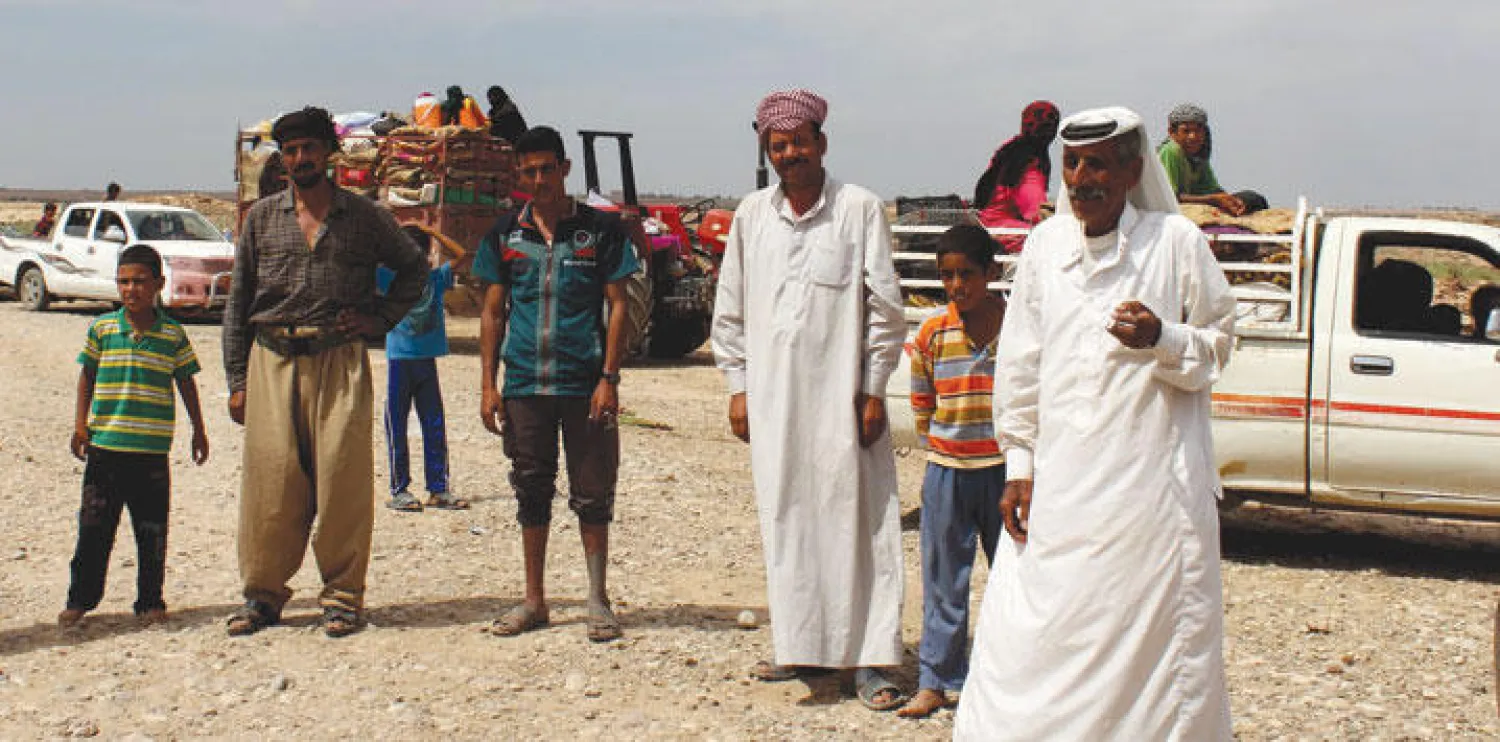 هاربون من قرى عربية خاضعة لـ«داعش» لدى وصولهم إلى مواقع البيشمركة جنوب كركوك أمس («الشرق الأوسط»)