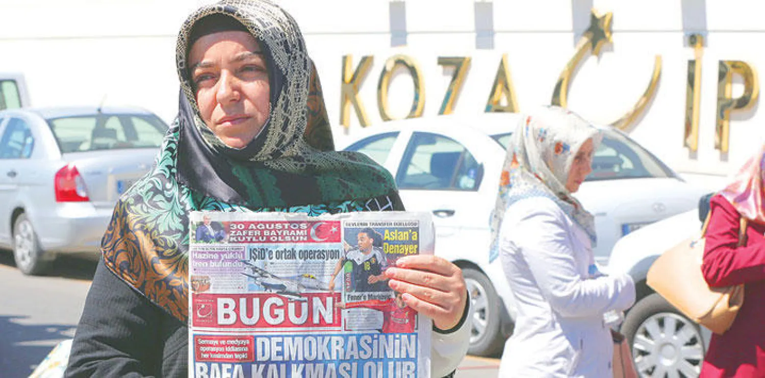 امرأة تركية تحمل نسخة من جريدة {بوغون} ضمن متظاهرين احتجوا أمس على اقتحام الأمن لمقر الجريدة في العاصمة أنقرة (أ.ب)