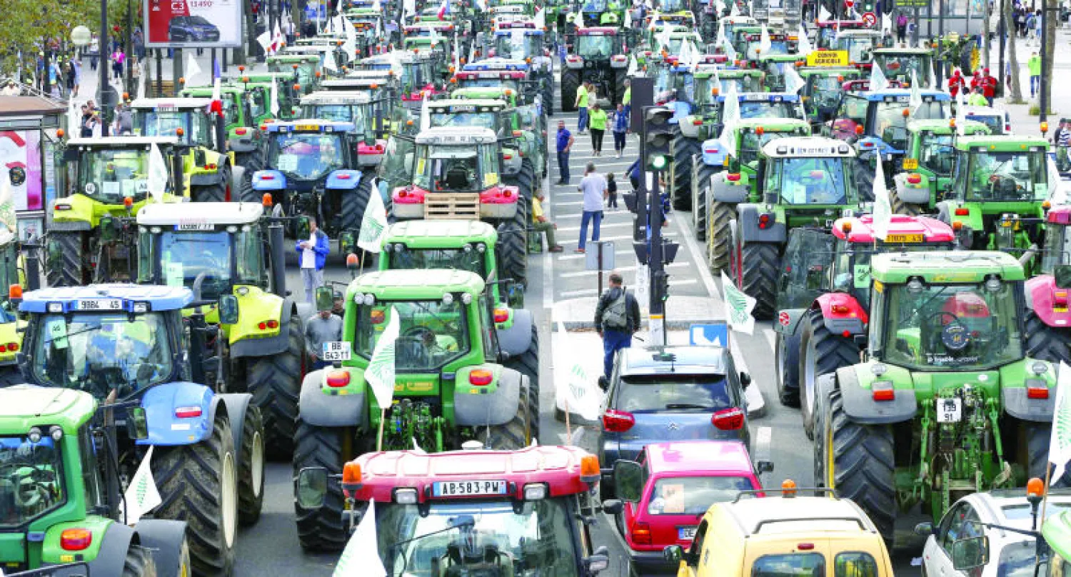 جانب من حصار المزارعين الذين ملأوا شوارع باريس أمس  بجراراتهم احتجاجًا على تراجع عائداتهم (أ.ف.ب)