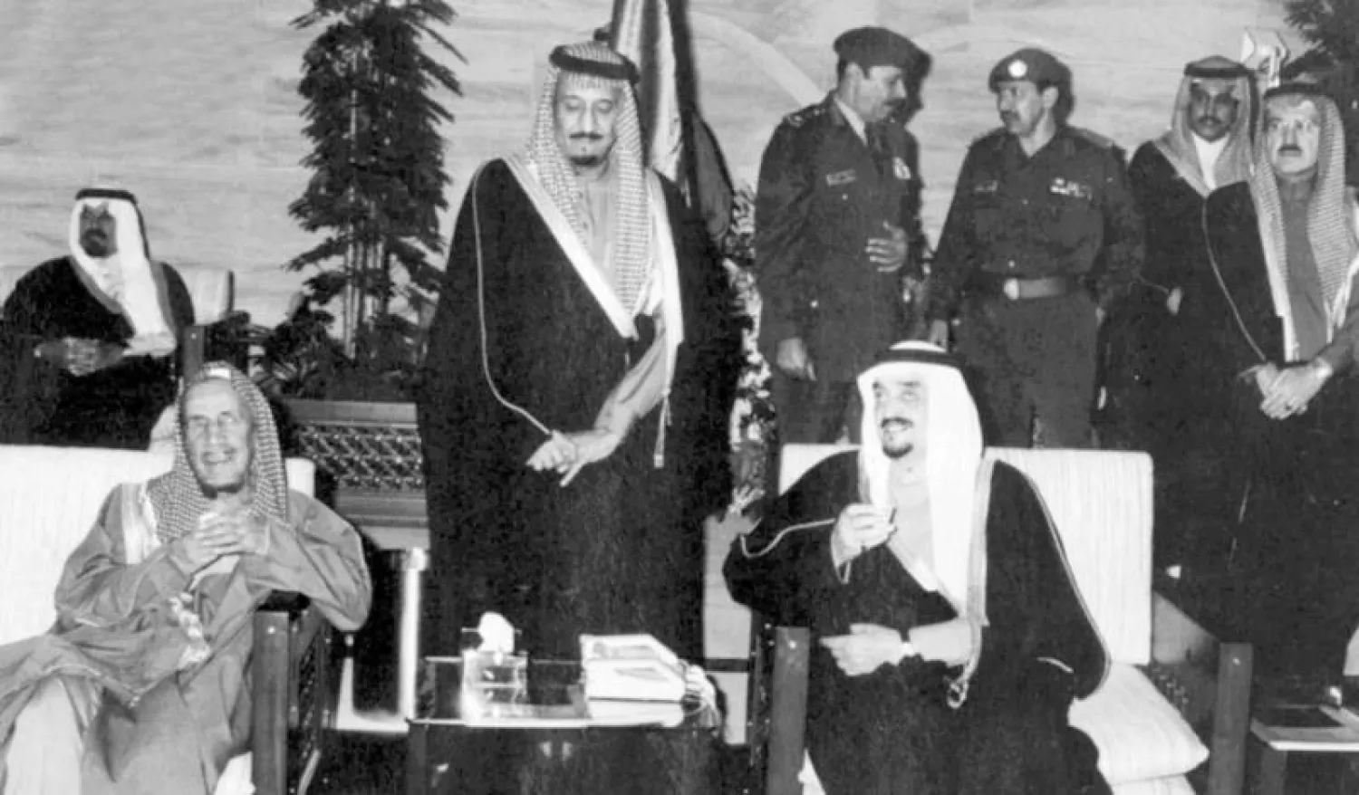 الملك الراحل  فهد بن عبد العزيز في حديث مع الشيخ الراحل عبد العزيز بن باز، والملك سلمان. ويظهر في الصورة الأمير الراحل سلطان بن عبد العزيز والأمير الراحل سطام بن عبد العزيز