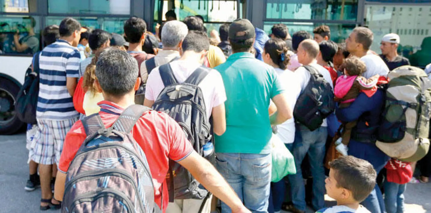 مهاجرون في أثينا بعد وصولهم من احدى الجزر اليونانية (أ.ب)